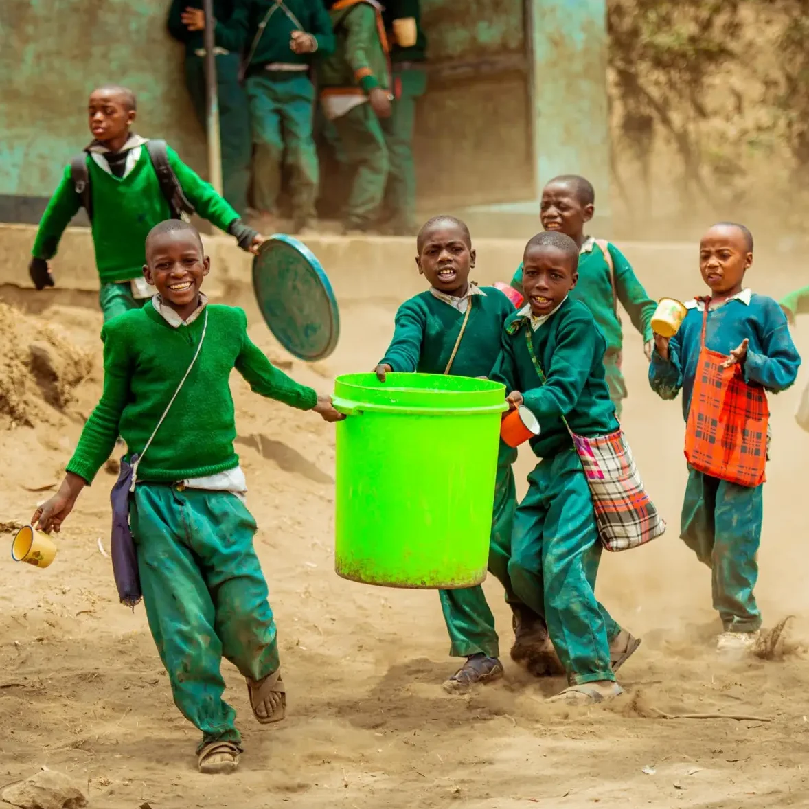 Children carry large water bucket